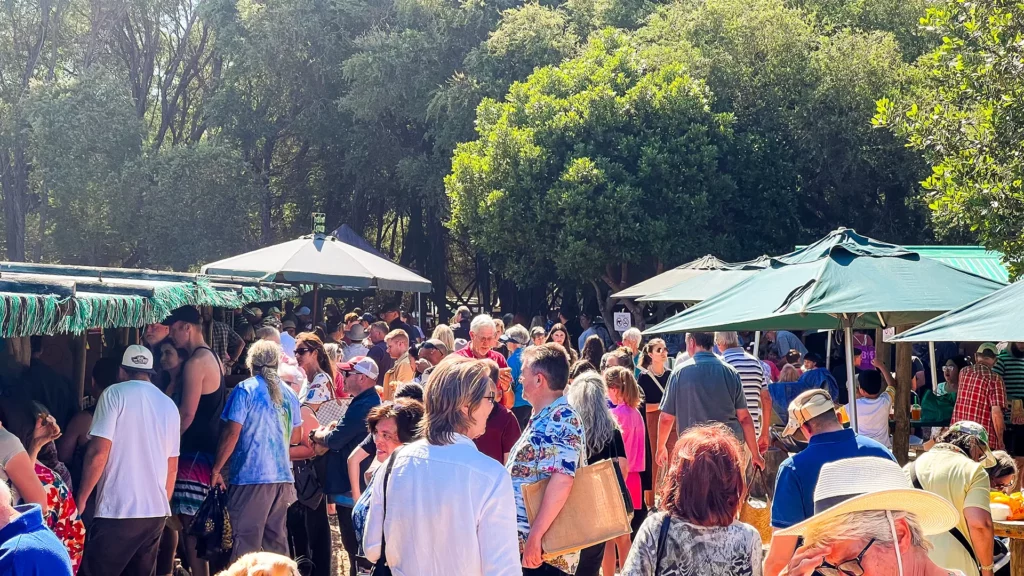 Crowd mingling and shopping at the busy Wild Oats Farmers Market.